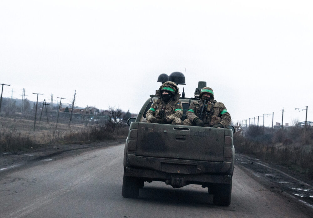 Ukrainian soldiers are seen traveling on the back of a military pickup. Donetsk Oblast, December 2025.