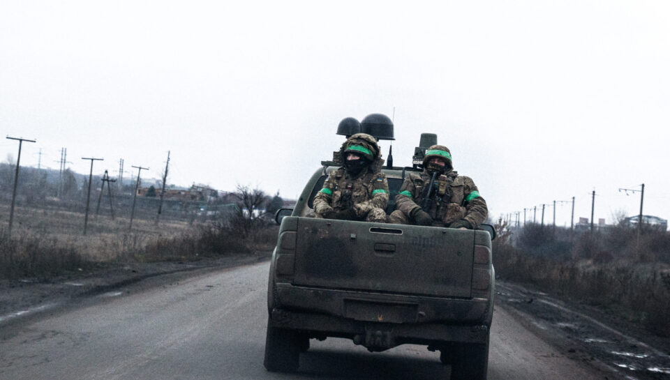Ukrainian soldiers are seen traveling on the back of a military pickup. Donetsk Oblast, December 2025.